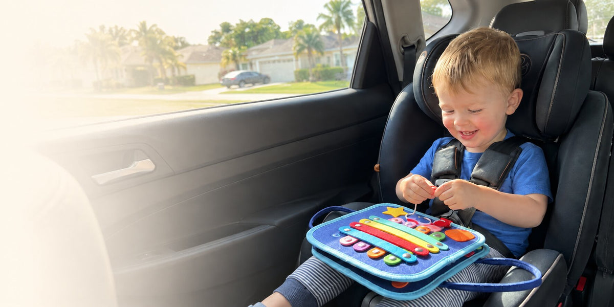 A child exploring a navy and mustard activity board